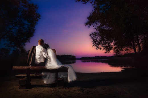 Brautpaar sitzend am See mit Sonnenuntergang